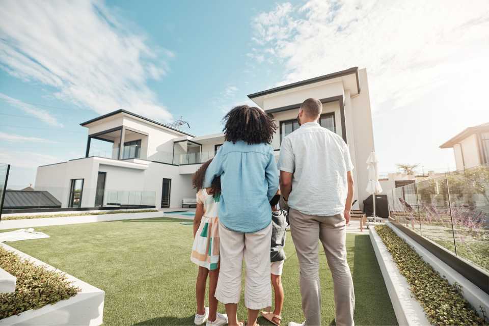 Multi-racial couple standing in front of house