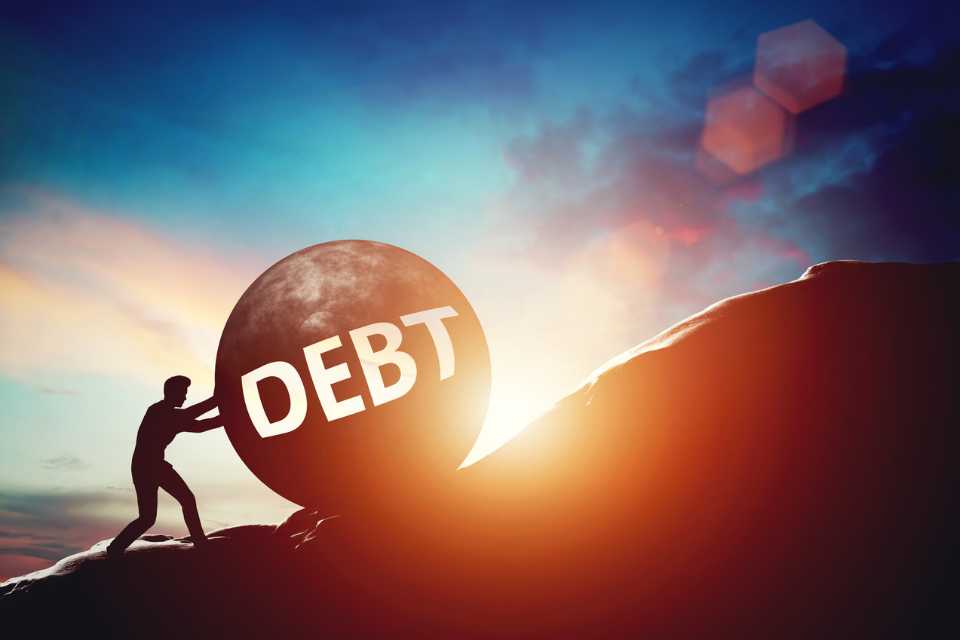 Man pushing a bolder up the debt mountain