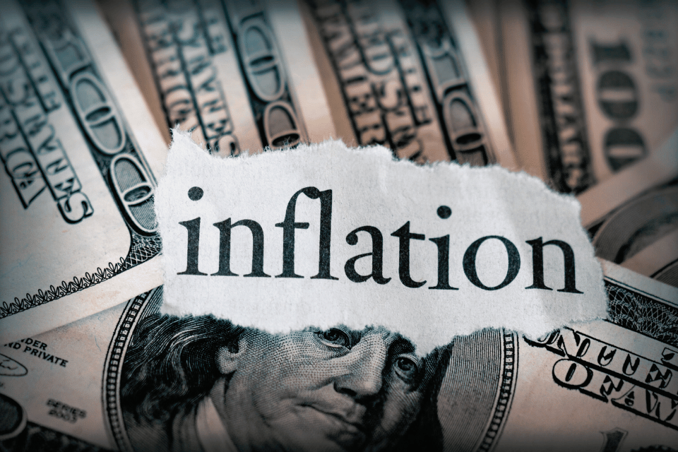 Image shows hundred dollar bills with the word inflation