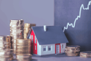 Image shows house with stacks of money and a rising curve symbolizing rising home prices