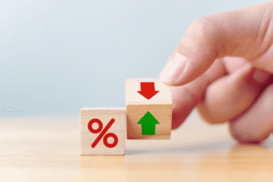Interest rate financial and mortgage rates concept. Hand flip wood cube change arrow down to up.